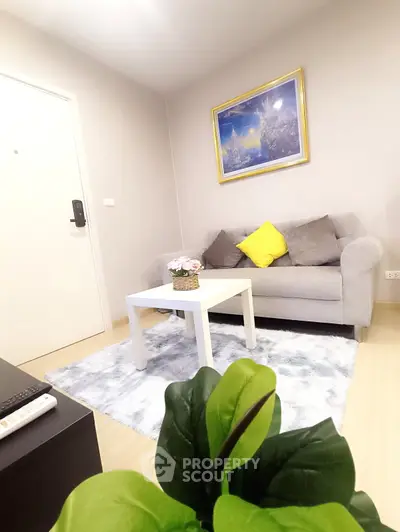 Cozy living room with modern decor, featuring a plush sofa, stylish rug, and vibrant artwork.