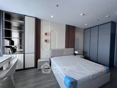 Modern bedroom with stylish decor and ample storage space, featuring a sleek bed and built-in wardrobe.