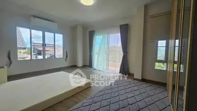 Spacious bedroom with large windows and balcony access, offering abundant natural light and scenic views.