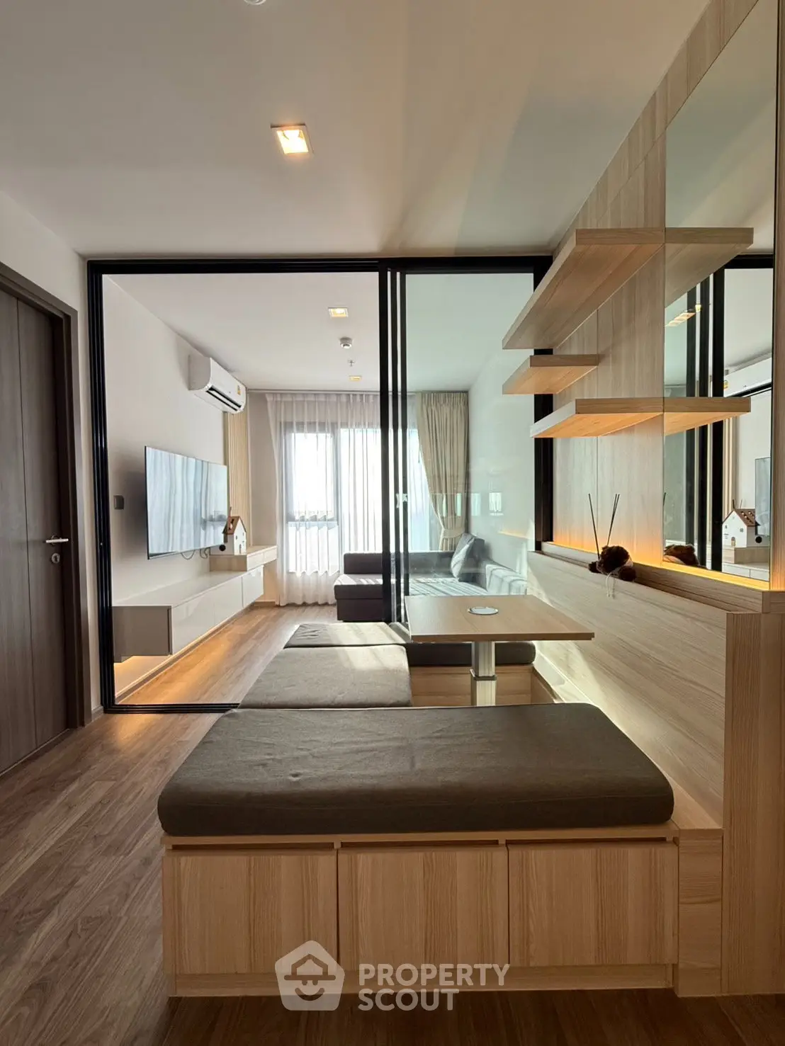 Modern living room with sleek wooden furniture and large window for natural light.