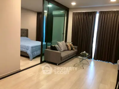 Modern studio apartment with glass partition, cozy living area, and stylish decor.