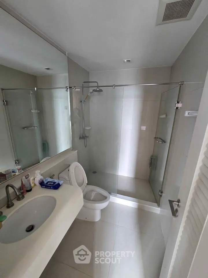 Modern bathroom with glass shower and sleek fixtures in a contemporary home.