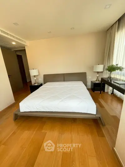 Spacious bedroom with modern decor and large windows for natural light