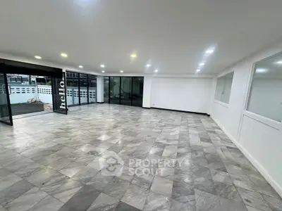 Spacious modern interior with marble flooring and large windows, perfect for versatile use.