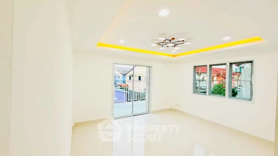Bright and spacious room with modern lighting and balcony access.