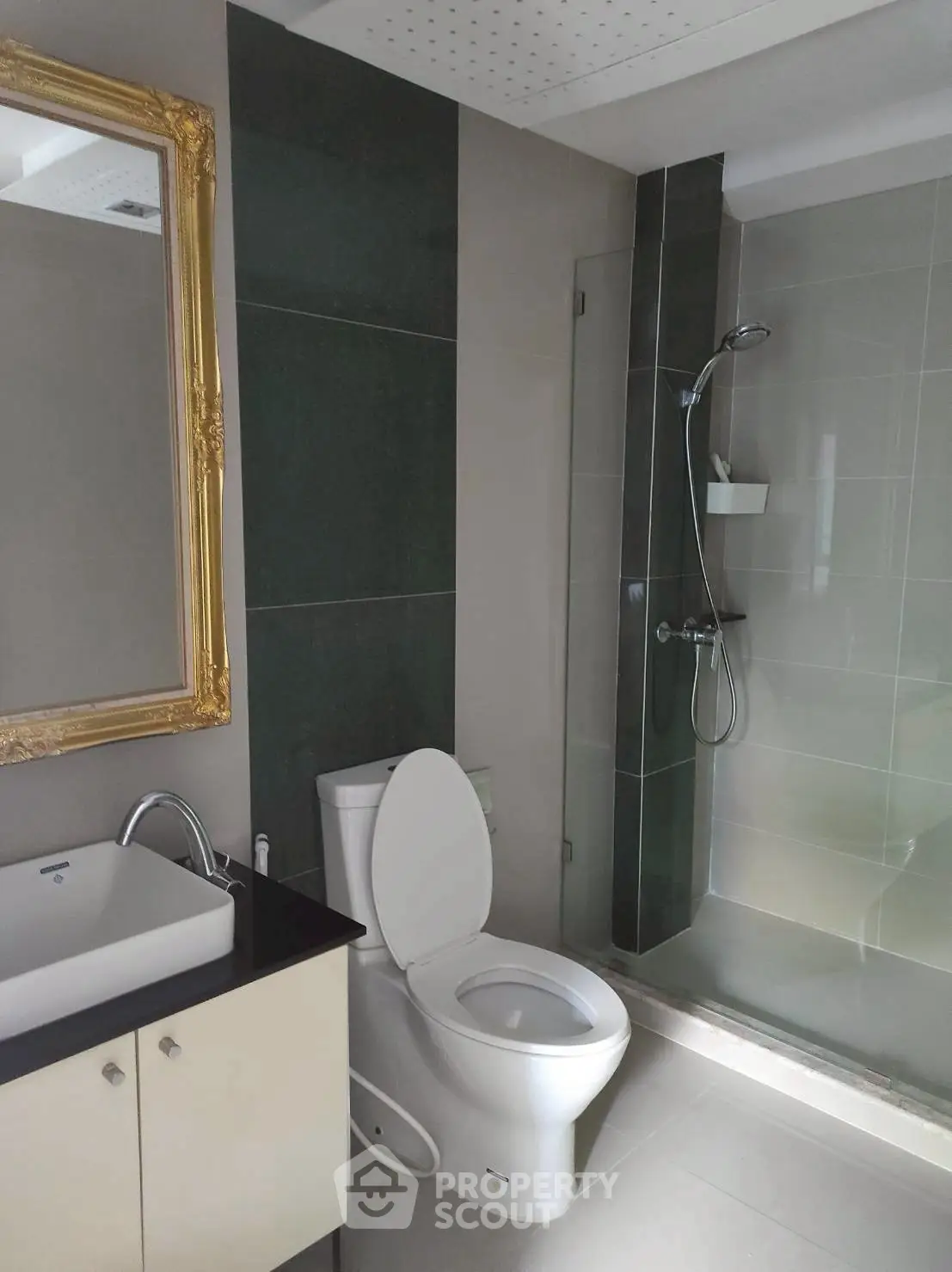 Modern bathroom with elegant shower and gold-framed mirror