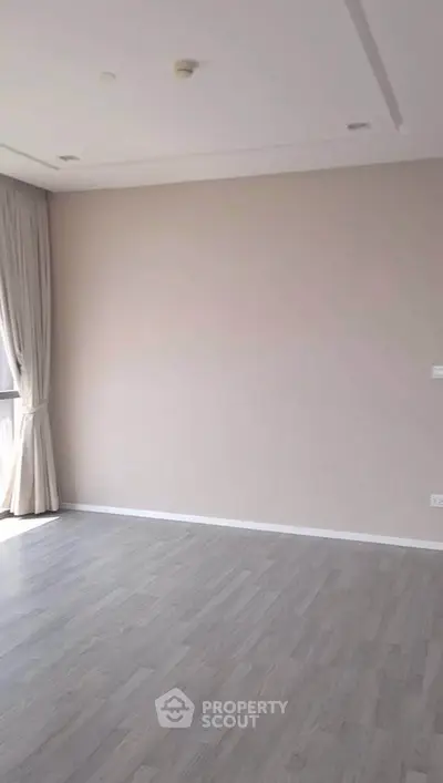 Spacious empty room with large window and elegant curtains, perfect for customization.