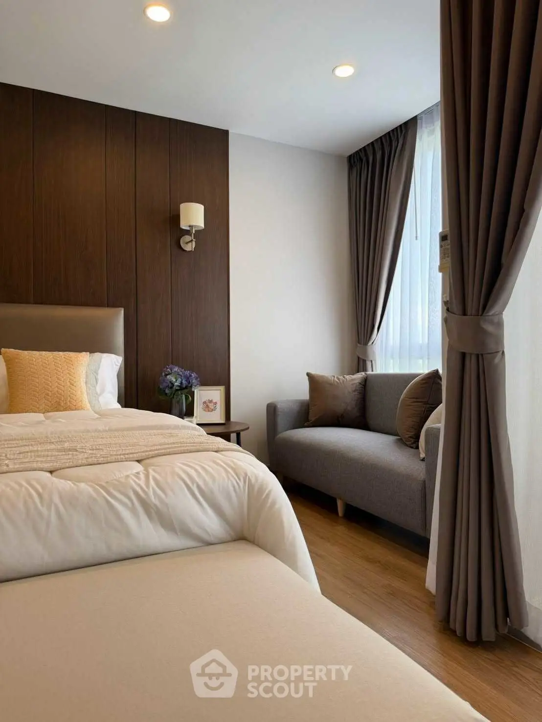 Cozy bedroom with elegant decor and natural light, featuring a comfortable bed and stylish seating area.