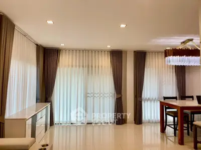 Spacious living room with elegant curtains and modern dining area, perfect for family gatherings.