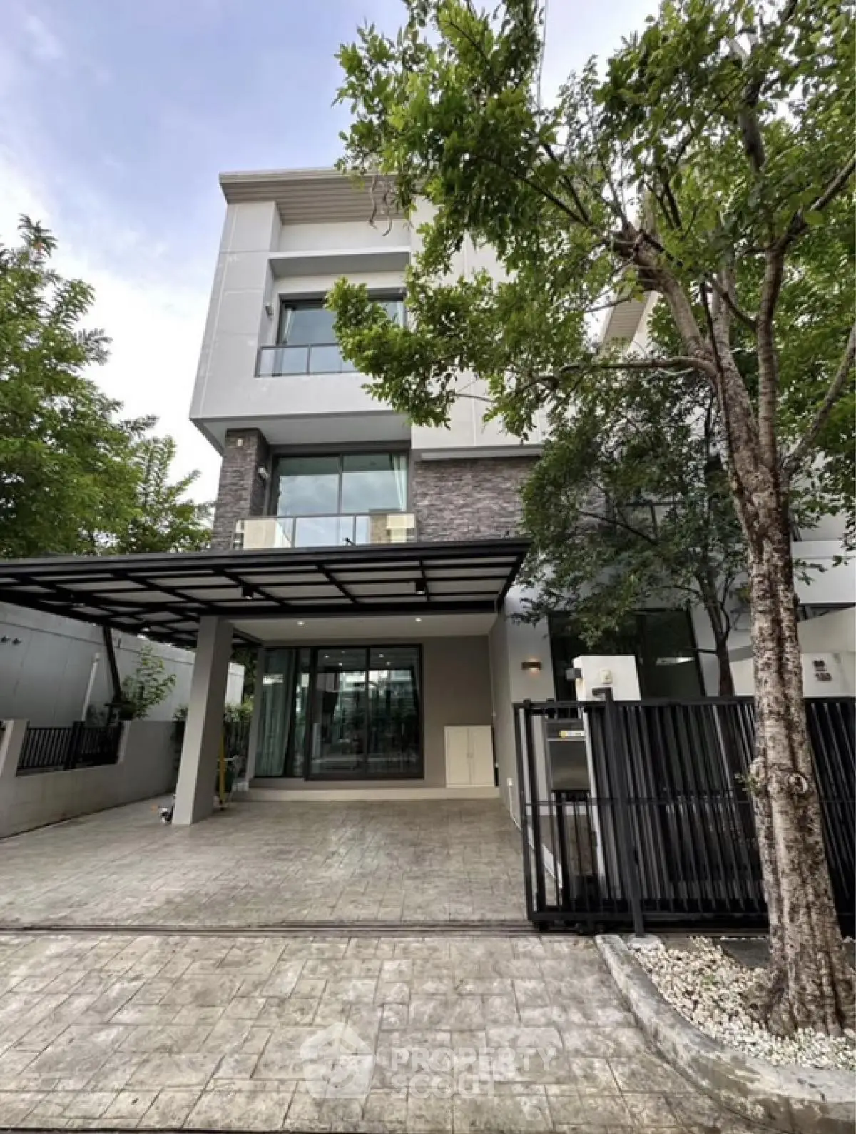 Modern three-story house with sleek design and spacious driveway