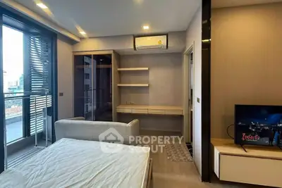 Modern bedroom with balcony access and sleek built-in storage in urban apartment