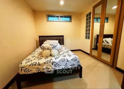 Cozy bedroom with single bed and mirrored wardrobe, perfect for a minimalist lifestyle.