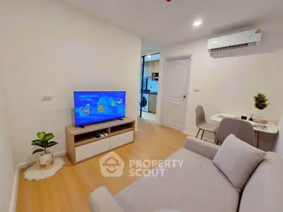 Modern living room with cozy sofa, flat-screen TV, and dining area in a stylish apartment.
