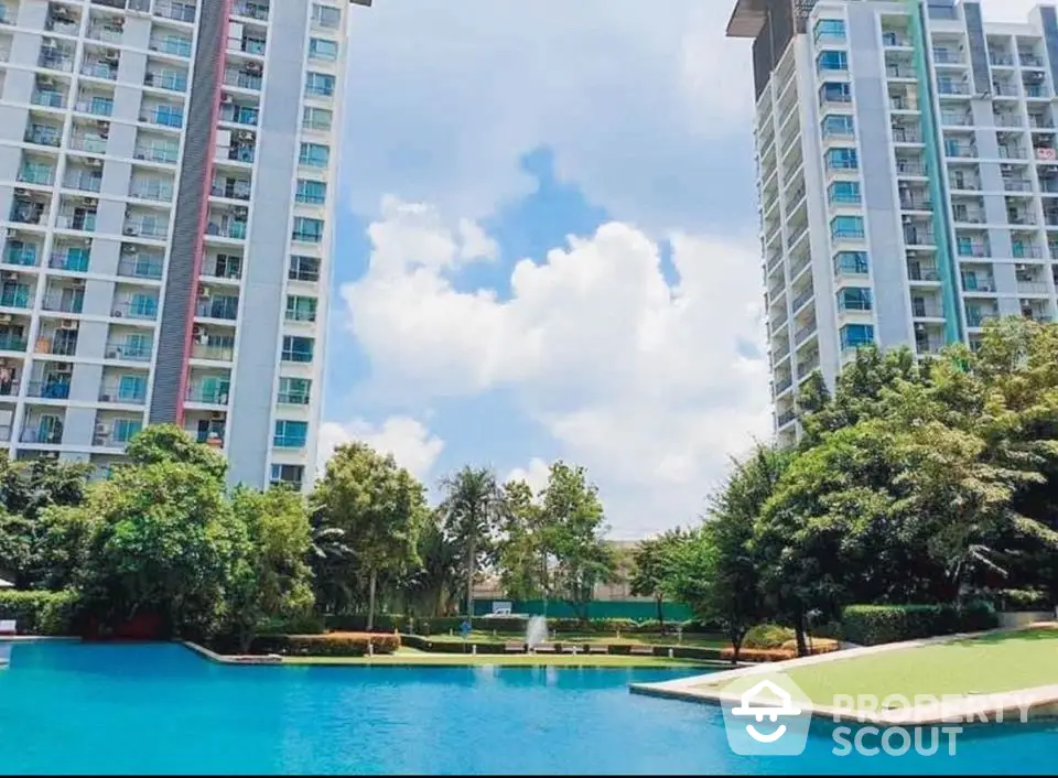 Luxurious residential towers with a stunning pool and lush greenery, perfect for modern living.