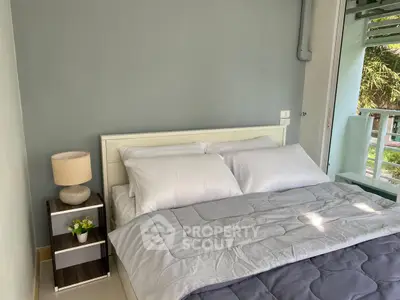 Cozy bedroom with modern decor and natural light, perfect for relaxation.