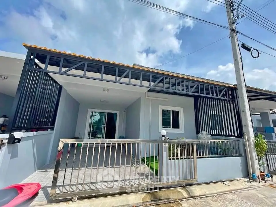 Charming single-story home with modern facade and gated entrance, perfect for family living.