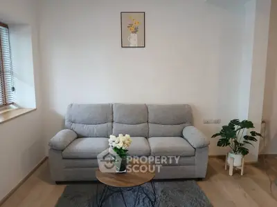 Cozy living room with a plush gray sofa, wooden coffee table, and stylish decor accents.