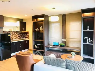 Modern living room with open kitchen, stylish decor, and cozy seating area in a contemporary apartment.