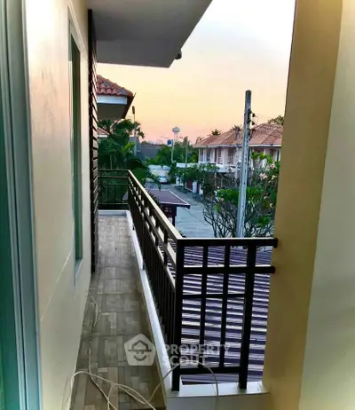 Charming balcony view with serene neighborhood setting at sunset, perfect for relaxation and enjoying the outdoors.