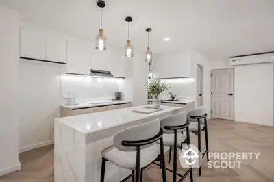 Modern kitchen with sleek island and stylish bar stools in a contemporary home.