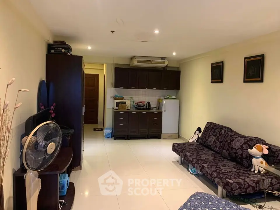 Cozy living room with open kitchen layout and modern furnishings in a stylish apartment.