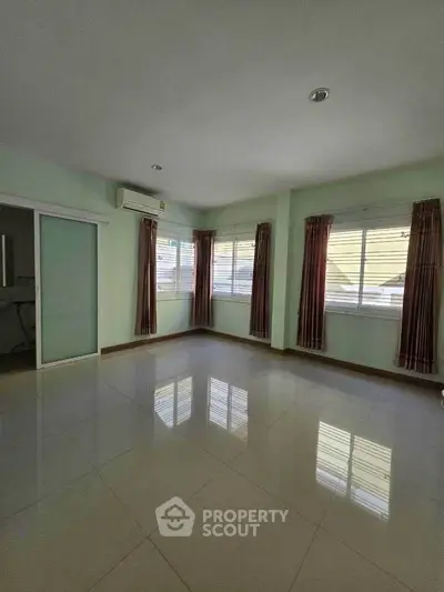 Spacious empty room with large windows and air conditioning unit