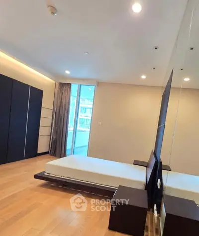 Spacious modern bedroom with large window and minimalist design