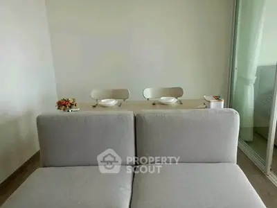 Modern living room with stylish gray sofa and elegant dining setup, perfect for cozy gatherings.