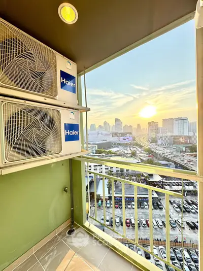 Stunning balcony view with city skyline and sunset, featuring air conditioning units.