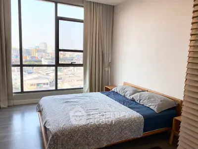 Modern bedroom with large window and city view, featuring a cozy double bed and stylish decor.