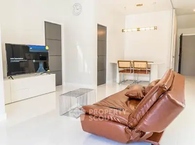Modern living room with sleek leather sofa and wall-mounted TV