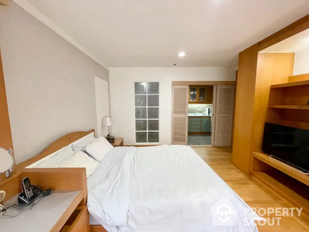 Spacious bedroom with modern amenities and open view to kitchen area