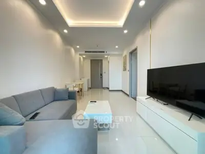Spacious modern living room with sleek furniture and large TV setup.