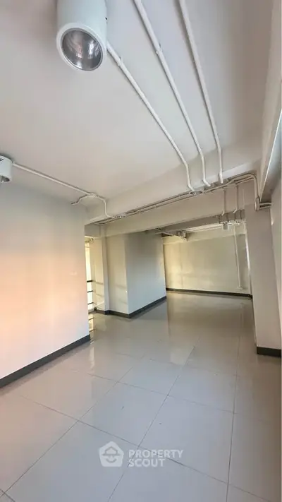 Spacious open-plan interior with modern lighting and tiled flooring, ideal for versatile use.