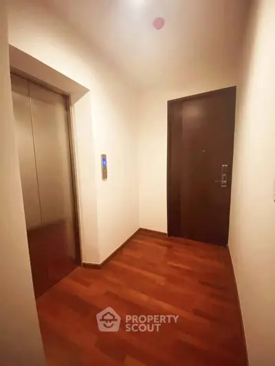 Modern apartment entrance with elevator and wooden flooring