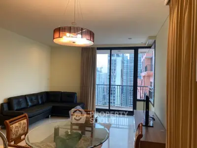 Spacious living room with modern furniture and city view balcony in luxury apartment.