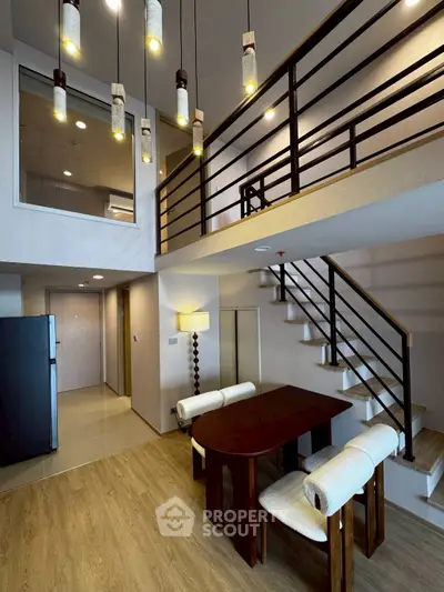 Modern duplex apartment with stylish dining area and elegant staircase