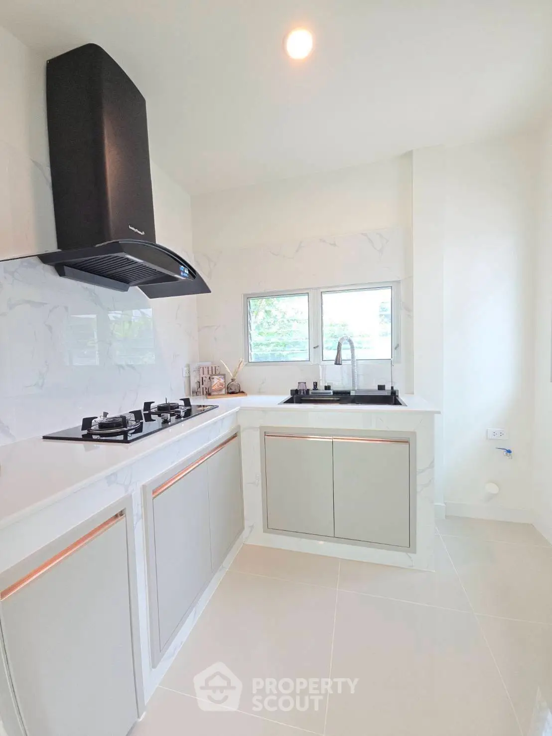 Modern kitchen with sleek cabinetry and gas stove in bright, airy space.