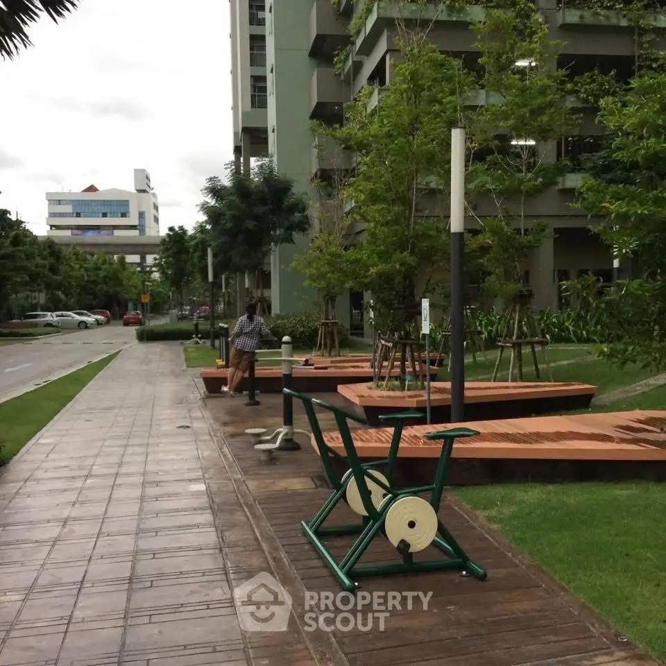 Modern apartment complex with outdoor fitness area and lush greenery.
