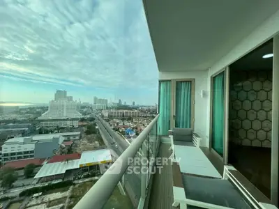Stunning city view from a modern high-rise balcony with sleek glass railing.
