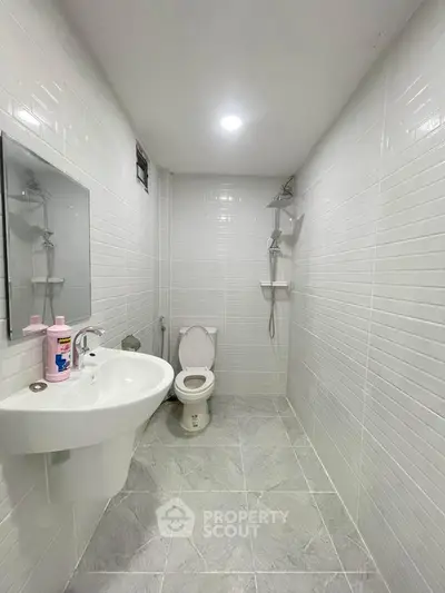 Modern minimalist bathroom with white tiles and sleek fixtures