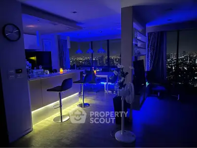 Stunning modern living room with city skyline view, ambient lighting, and sleek bar area.