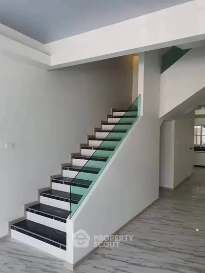 Modern staircase with sleek glass railing in contemporary home interior