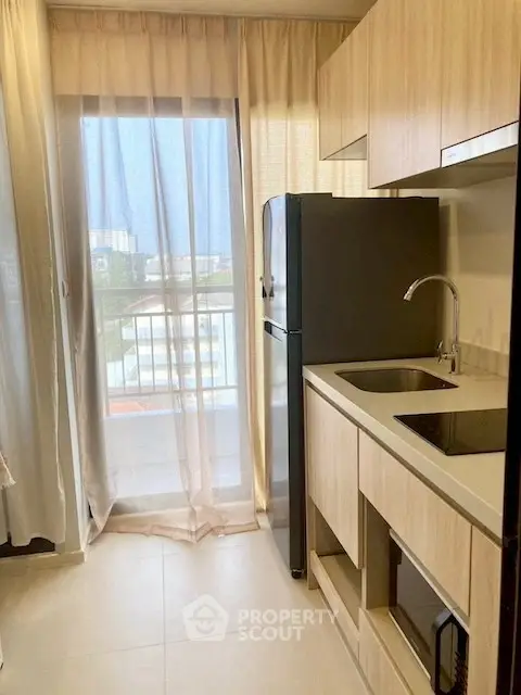 Modern kitchen with sleek cabinetry and large window offering natural light and city views.
