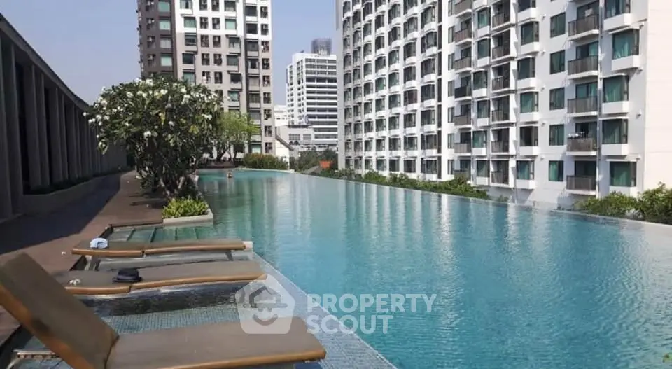 Luxurious rooftop pool with cityscape views in modern high-rise building.