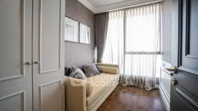 Charming small living room with elegant sofa and natural light through large window.