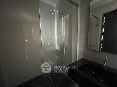 Modern bathroom with sleek glass shower and dark marble flooring