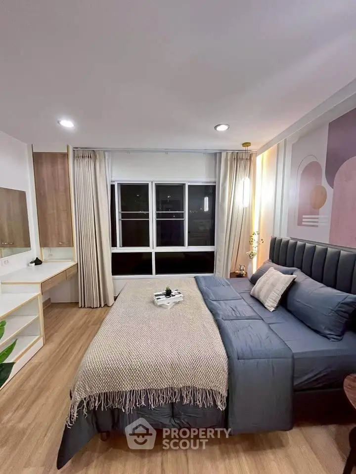 Modern bedroom with stylish decor and large window offering city views, perfect for urban living.