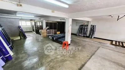 Spacious industrial storage space with concrete flooring and ample natural light.