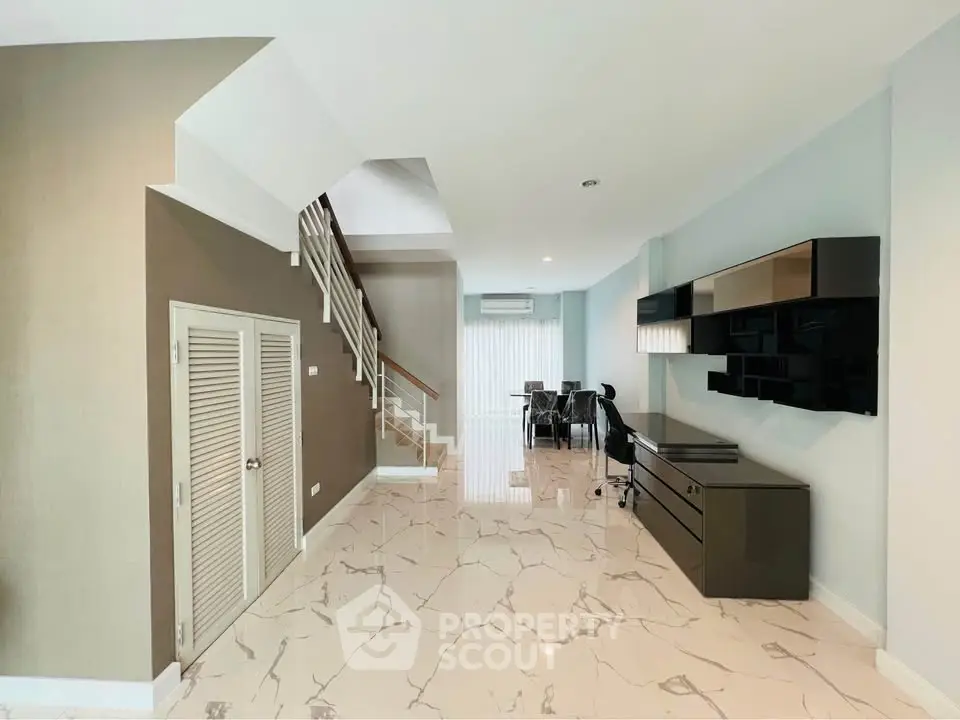 Spacious modern living room with marble flooring and sleek furniture design.